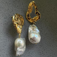 Gouden statement oorbellen met barokparels