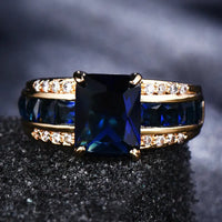Gouden ring met blauwe steen en zijstenen