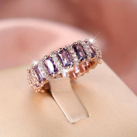 Roségouden ring met paarse baguette zirkonia rondom