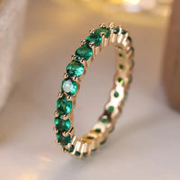 Gouden eternity ring met groene edelstenen