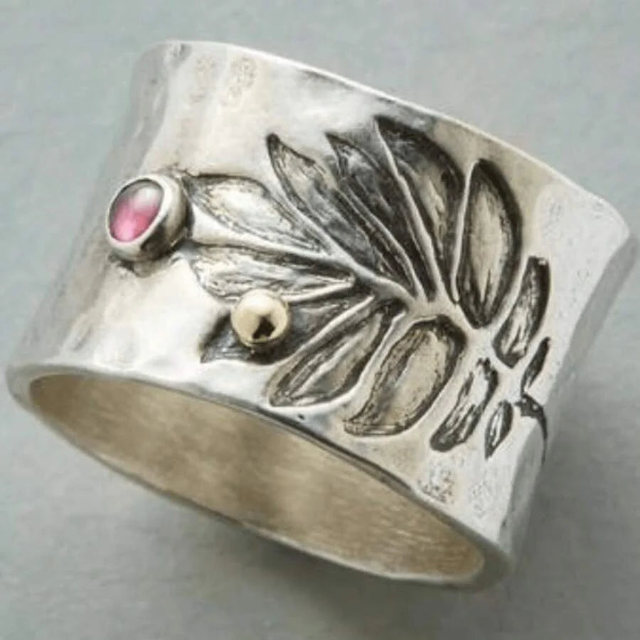 Zilveren brede ring met bladmotief en roze edelsteen