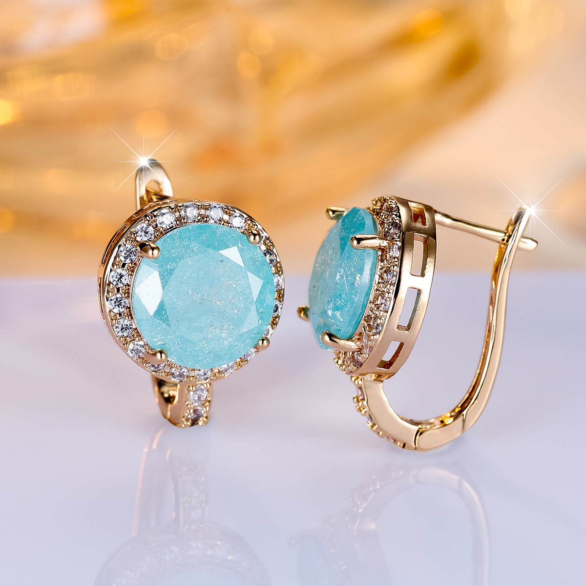 Gouden clip-oorbellen met ronde turquoise steen en zirkonia