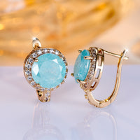 Gouden clip-oorbellen met ronde turquoise steen en zirkonia