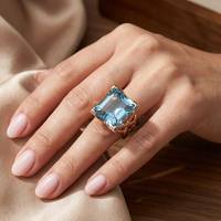 Roségouden ring met grote blauwe edelsteen en gevlochten band