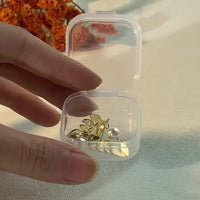 Gouden oorbellen met blad en hangende parel