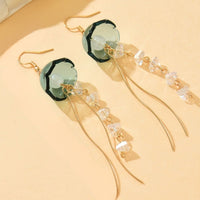 Gouden tassel oorbellen met groene glazen steen