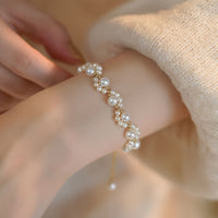 Gouden armband met parelclusters en hangbedeltje