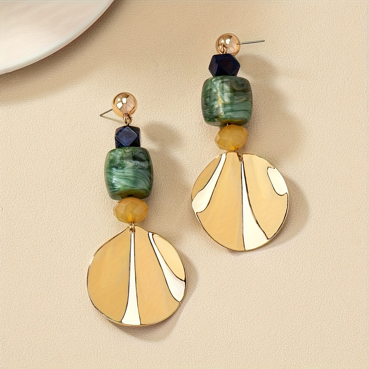 Gouden bohemian oorbellen met groene en crème schijf