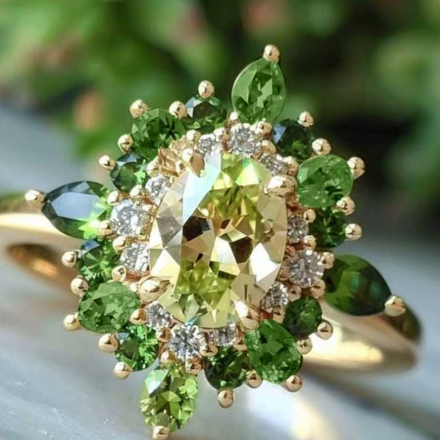 Gouden ring met groene edelstenen en halo