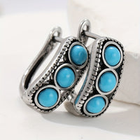 Zilveren huggie oorbellen met drie turquoise stenen