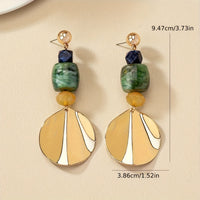 Gouden bohemian oorbellen met groene en crème schijf