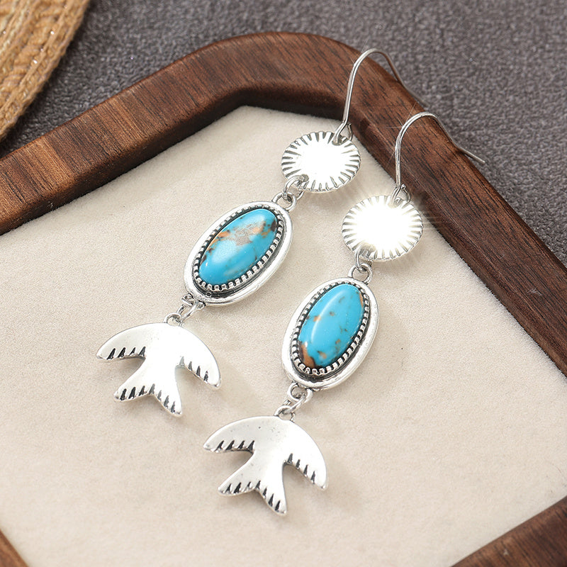 Zilveren oorbellen met ovale turquoise en vogelhanger