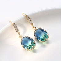 Gouden oorbellen met ovale blauwgroene steen