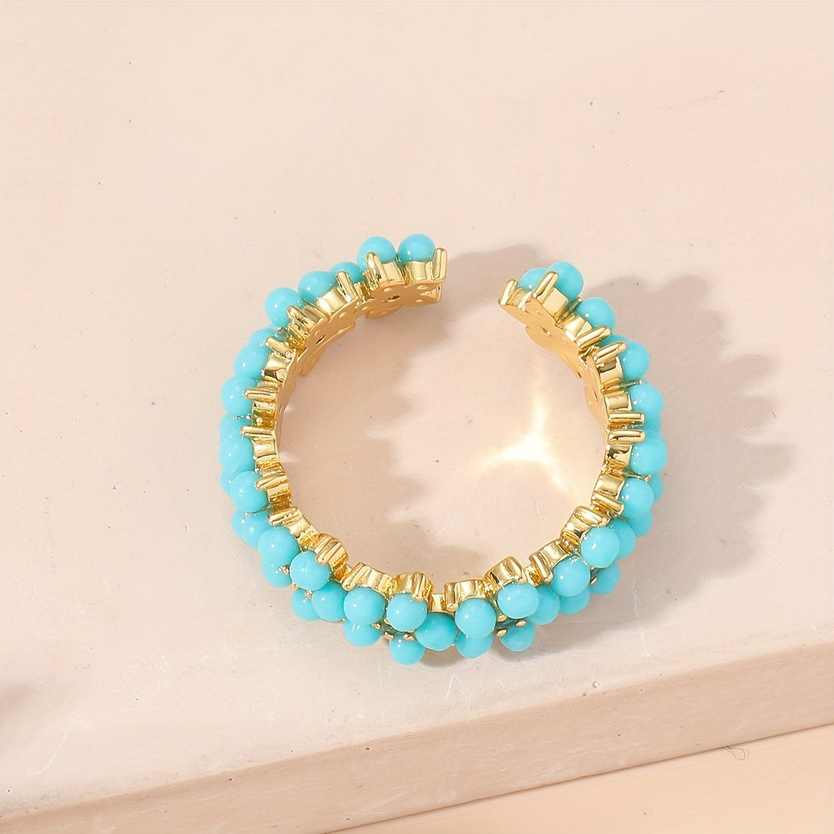 Gouden ring met turquoise kralen bloemmotief