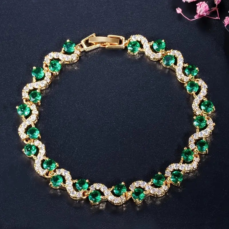 Gouden armband met groene en heldere kristallen