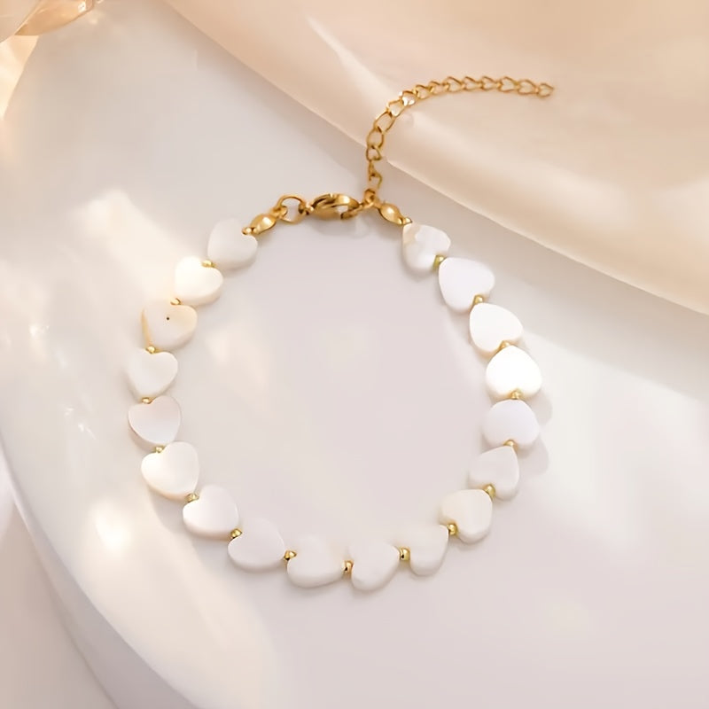 Gouden armband met witte parelmoer hartjes