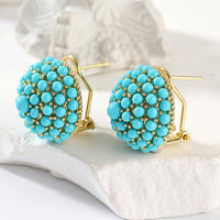 Gouden oorbellen met turquoise koepel van kralen