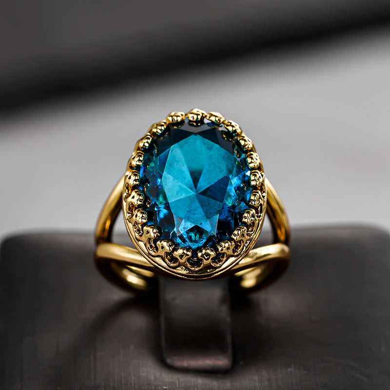 Gouden vintage ring met ovale blauwe edelsteen in kroonzetting