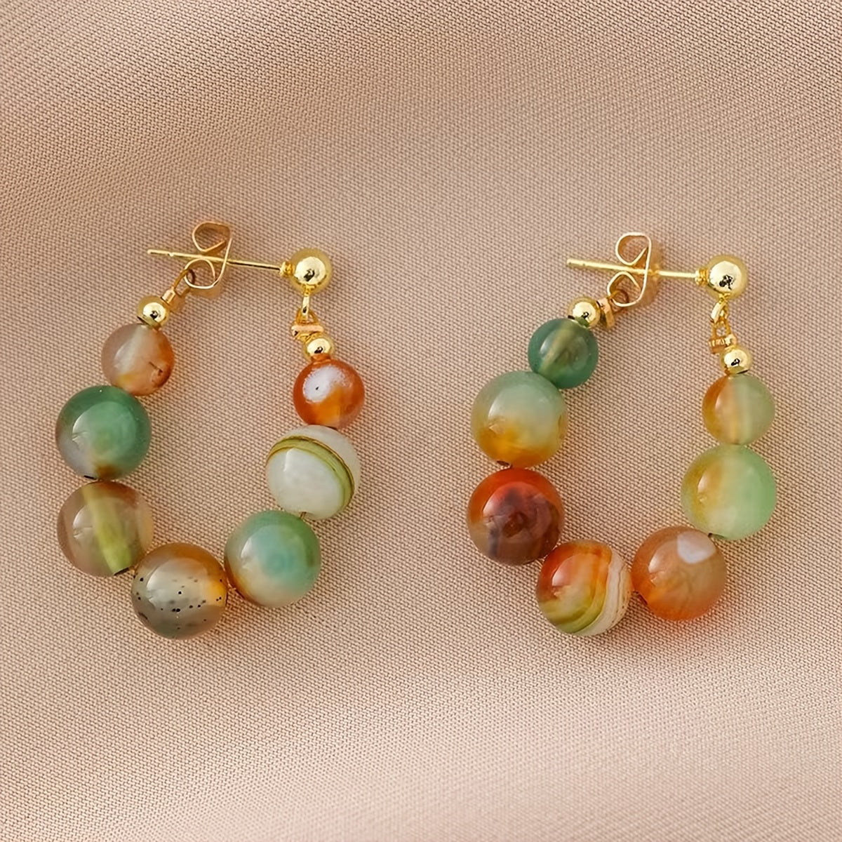 Gouden boho oorbellen met groene en oranje agaatkralen