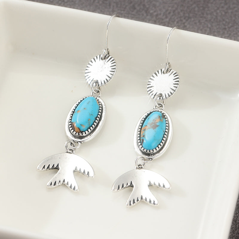 Zilveren oorbellen met ovale turquoise en vogelhanger