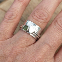 Zilveren spinner ring met hart en groene steen