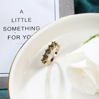 Gouden ring met vijf groene edelstenen