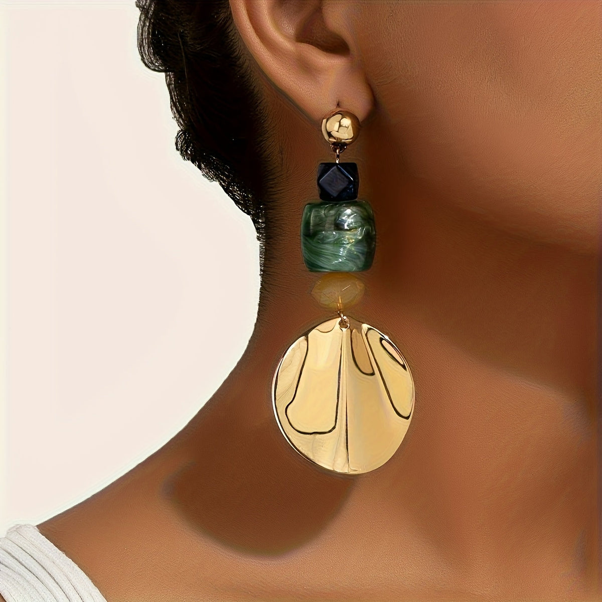 Gouden bohemian oorbellen met groene en crème schijf
