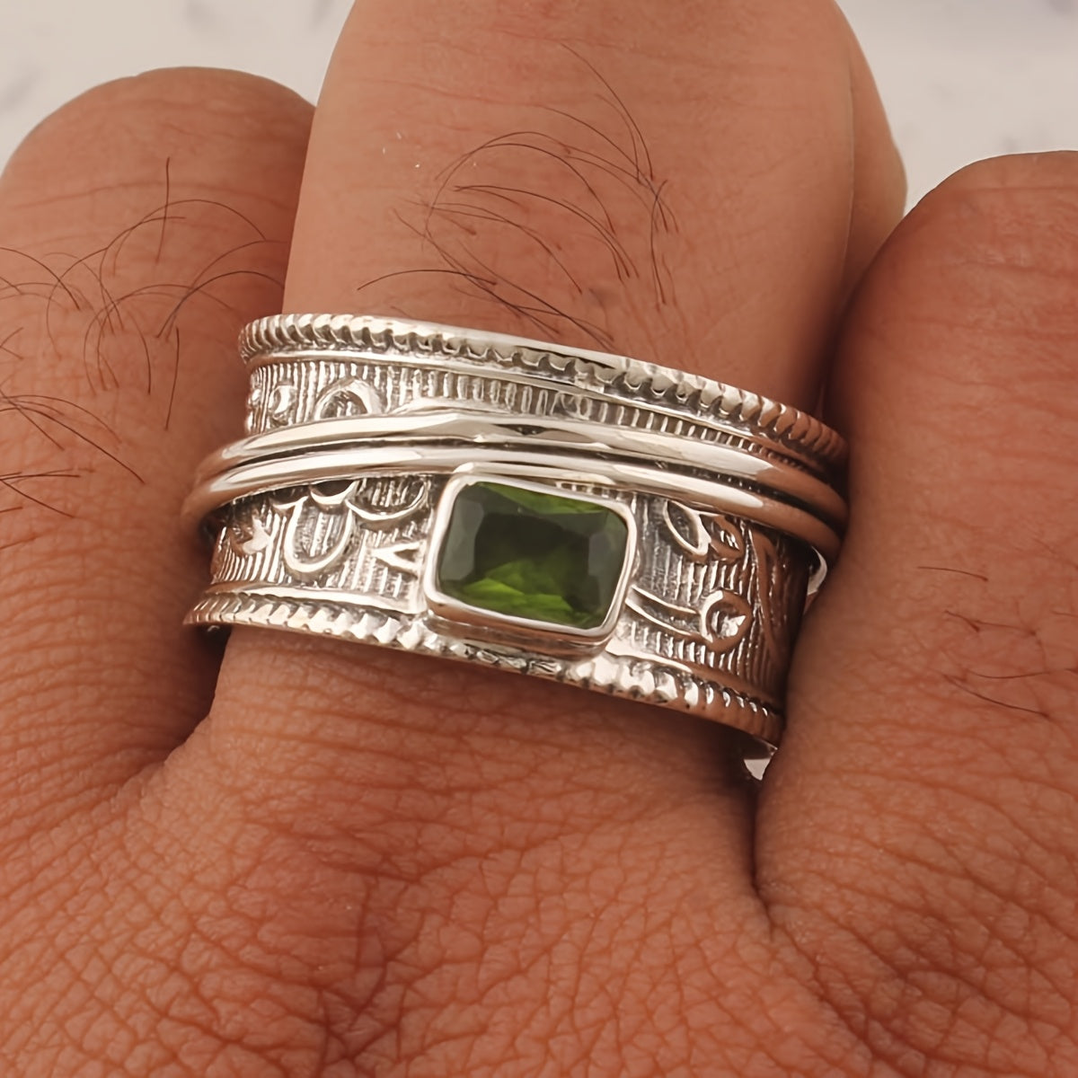 Zilveren gehamerde spinner ring met peridoot
