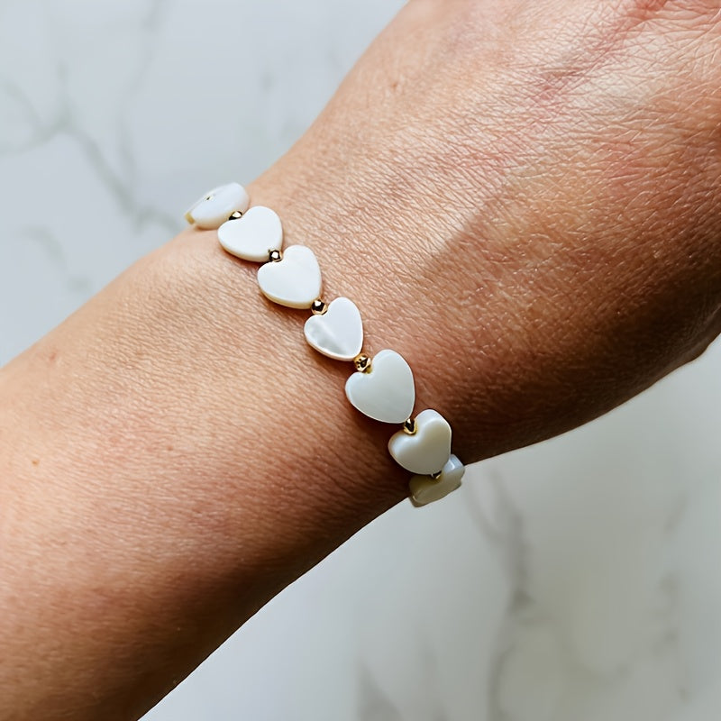 Gouden armband met witte parelmoer hartjes
