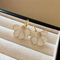 Gouden oorbellen met witte parelmoer bloem