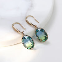 Gouden oorbellen met ovale blauwgroene steen