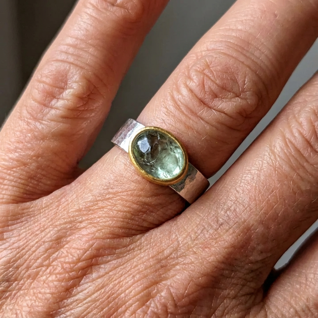 Zilveren brede ring met groene edelsteen in goud