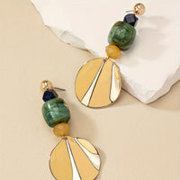 Gouden bohemian oorbellen met groene en crème schijf