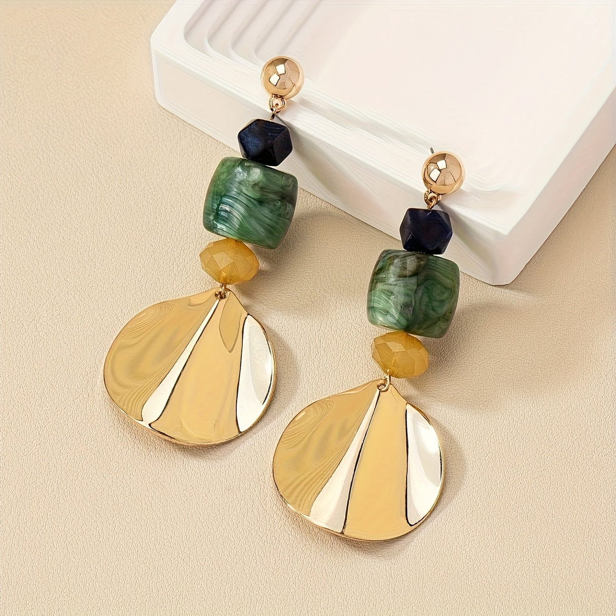 Gouden bohemian oorbellen met groene en crème schijf