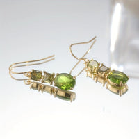 Gouden oorbellen met groene en gele edelstenen