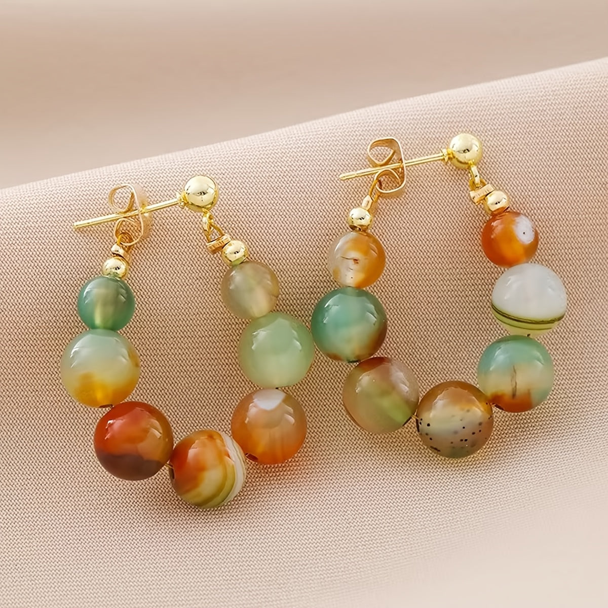 Gouden boho oorbellen met groene en oranje agaatkralen