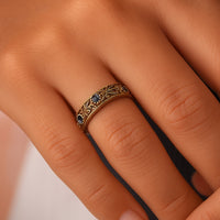 Gouden eternity-ring met blauwe stenen en bladmotief