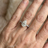 Gouden solitairering met peervormige zirkonia en pavé band