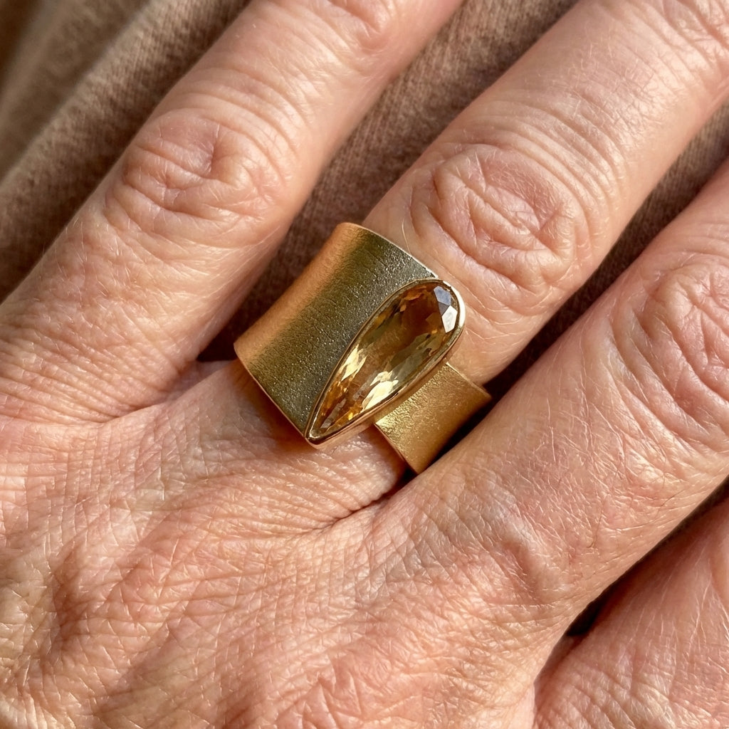 Gouden brede ring met peervormige champagne edelsteen
