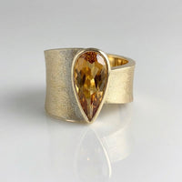 Gouden brede ring met peervormige champagne edelsteen