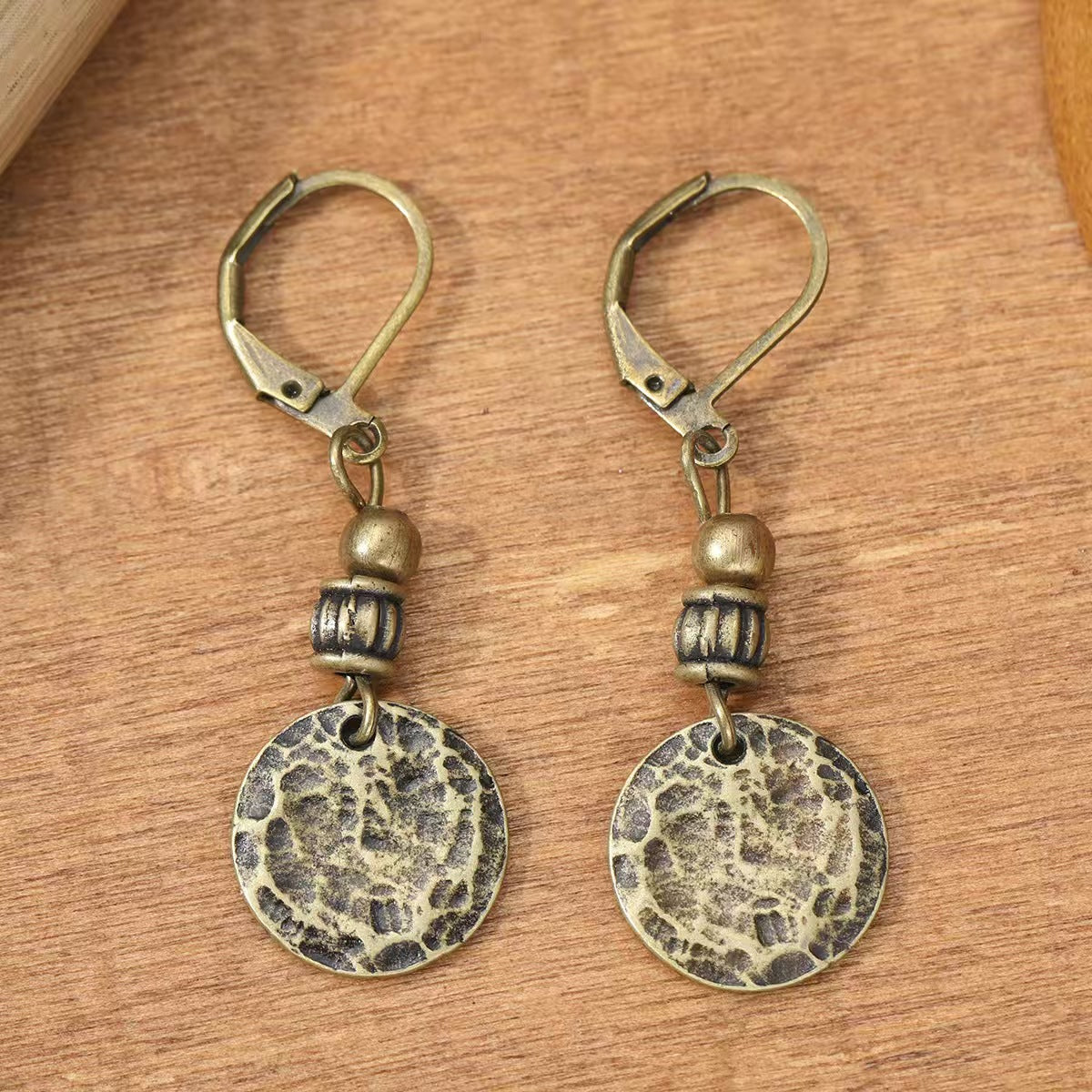 Bronzen vintage oorbellen met gehamerde munthanger