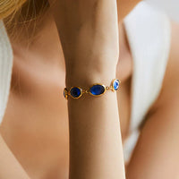Gouden armband met blauwe ovale edelstenen