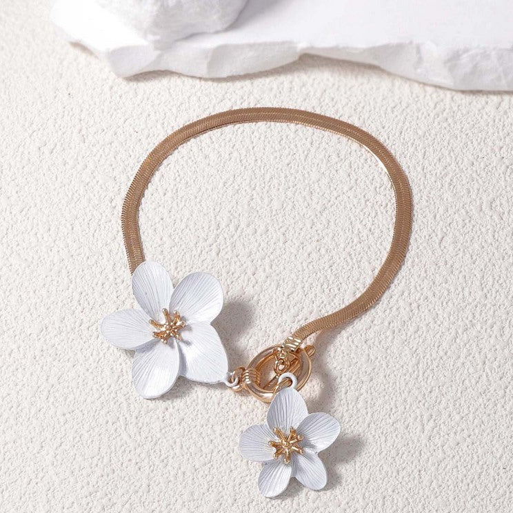Gouden armband met twee witte bloemen