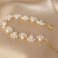 Gouden armband met parelclusters en hangbedeltje