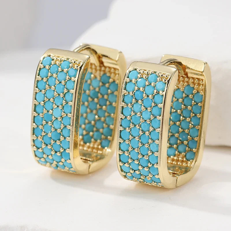 Gouden huggie-oorbellen met turquoise pavé