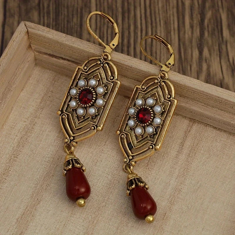 Gouden vintage oorbellen met parels en rode druppel