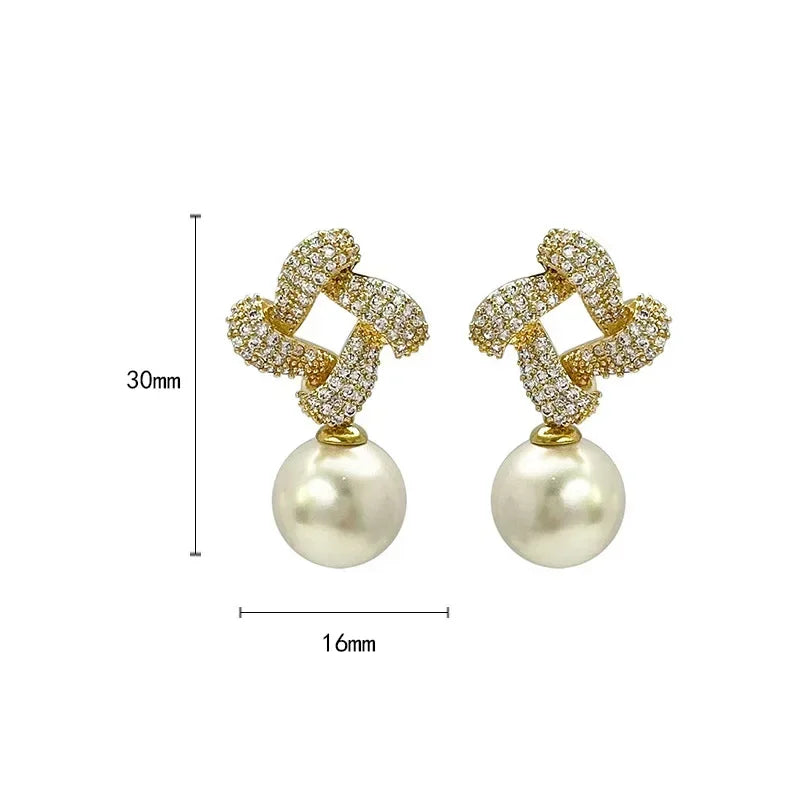 Gouden oorbellen met kristallen knoop en parelhanger
