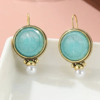 Gouden vintage oorbellen met turquoise intaglio en parel
