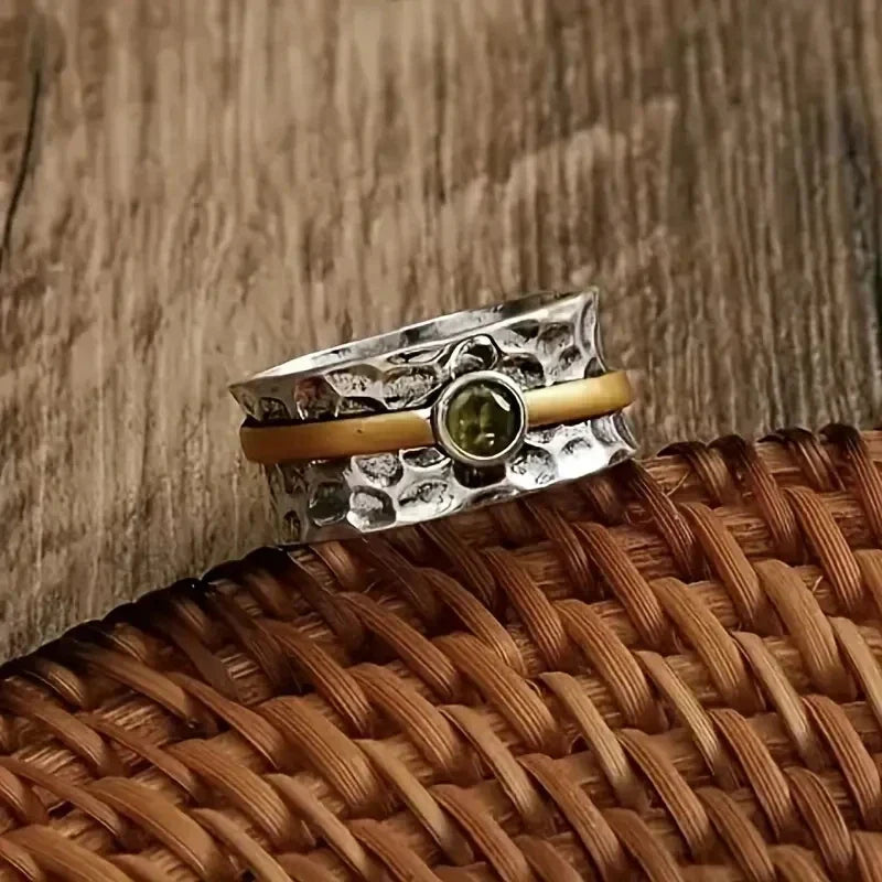 Zilver-gouden gehamerde spinner ring met peridoot