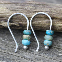 Minimalistische zilveren oorbellen met turquoise kralen